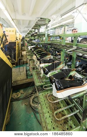 MOSCOW, RUSSIA - FEBRUARY 21, 2017: Moscow shoe factory JSC RALF RINGER. Black lacquer shoes on the conveyor of the shoe factory.