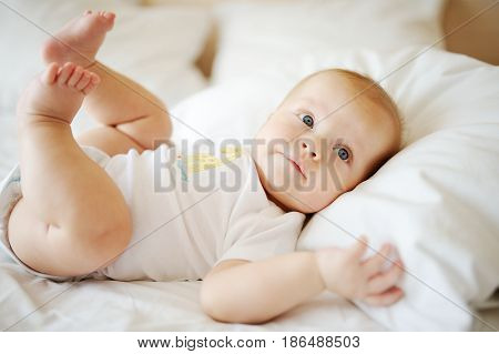 Portrait of a young child in white clothes against the background of a baby crib