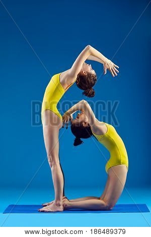 Two Young Women Doing Yoga Asana Standing Backbend Pose