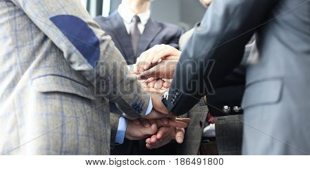 Businessman team in suit touching hands together. Selective focus