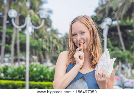 Women Eat Fried Sweet Potatoes In The Park. Junk Food Concept