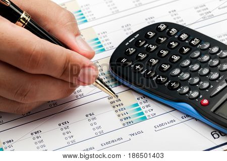 Close-up of a Businessman Analyzing Financial Figures with Calculator