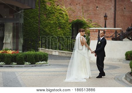 Groom Admies A Bride While She Looks Over Her Shoulder
