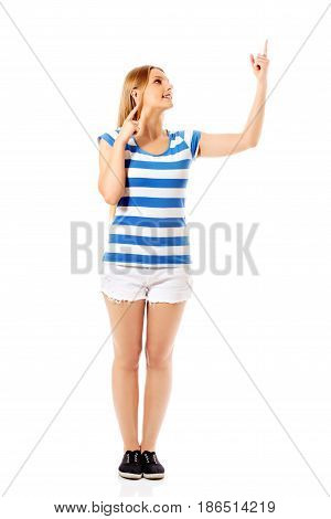 Young woman pointing to somewhere, isolated over a white background