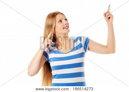 Young woman pointing to somewhere, isolated over a white background