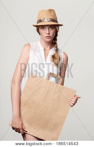 Beautiful fashion woman holding craft shopping bag with empty copy space