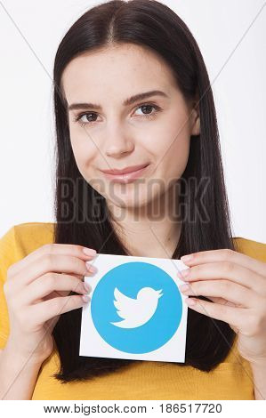 KIEV, UKRAINE - AUGUST 22, 2016: Woman hands holding Twitter logotype icoi bird printed paper close up. Twitter is an online social networking service that enables users to send and read short messages.