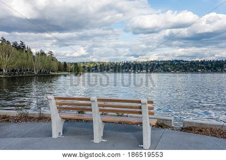 A view of Mercer Island with a bench in the foreground. Shot taken from Seward Park in Seattle.