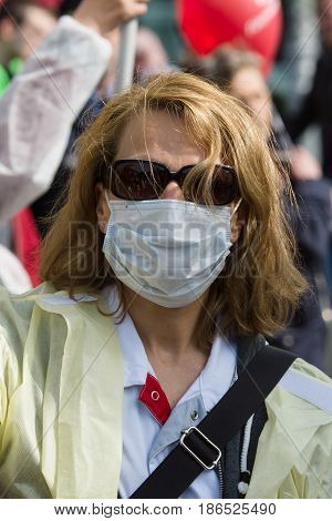 BERLIN - MAY 01 2016: Woman in a medical mask. Members of trade unions workers and employees at the demonstration on the occasion of Labour day.