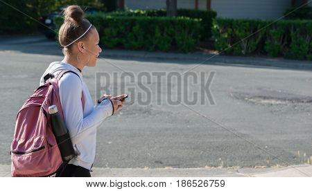 Teenage Girl with Cellphone and Backpack going to school