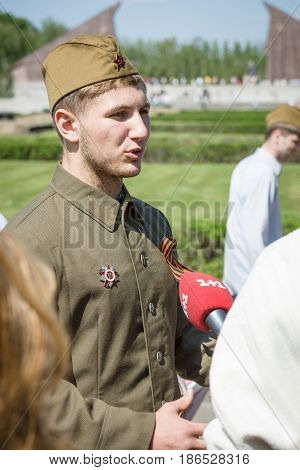 BERLIN - MAY 08 2016: Victory in Europe Day. Soviet War Memorial in Treptower Park. Journalist Ukrainian TV station 1+1 is interviewing a young man dressed in the form of a Soviet soldier during the war.