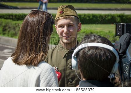 BERLIN - MAY 08 2016: Victory in Europe Day. Soviet War Memorial in Treptower Park. Journalist Ukrainian TV station 1+1 is interviewing a young man dressed in the form of a Soviet soldier during the war.