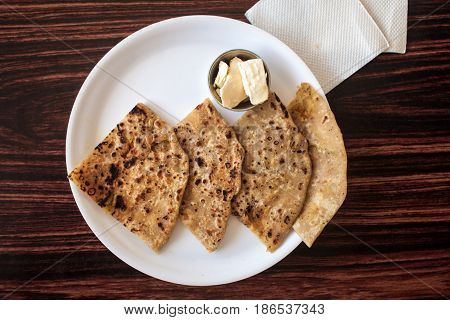 Traditional Indian flat cakes - chapatis with butter on a white plate