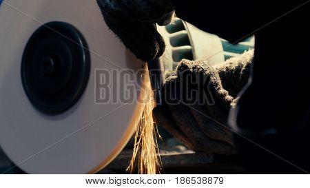 Close up of man's hands working with a circular grindstone