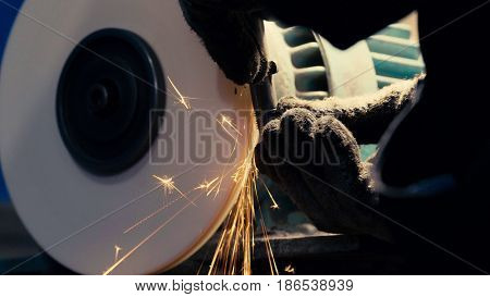 Close up of man's hands working with a circular grindstone