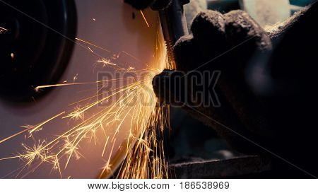 Close up of man's hands working with a circular grindstone