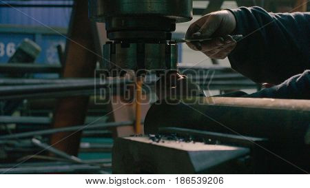 Close up of men's hands screwing the milling cutter on the milling machine