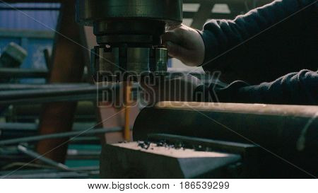 Close up of men's hands screwing the milling cutter on the milling machine