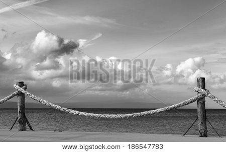 Black and white view on seafront and sky with sunlight clouds in autumn evening. Turkey Erdek coast of Marmara.