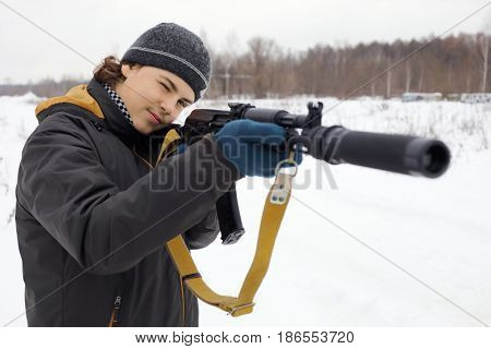Teen with gun takes aim during lasertag game outdoor at winter