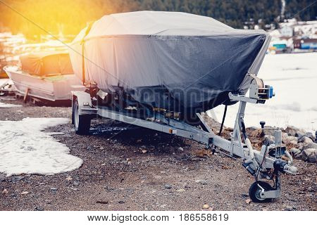 boat is covered with a tent, Cover, case against rain, snow and mud.. Warehouse on the boat pier. Concept training of boats, ships for the winter in the home.