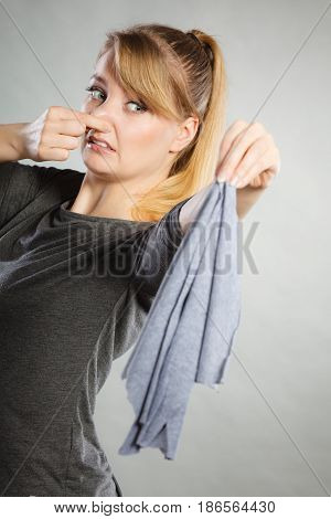 Household duties concept. Young disgust girl holding cleaning cloth rag doing domestic chores. Unhappy housewife.
