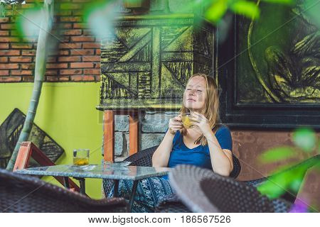Young Beautiful Redhead Woman Sitting In A Cafe Drinking A Delicious Morning Ginger Tea In A Cafe