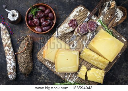 Traditional French cold cuts with Cheese and Salami as top view on old cutting board