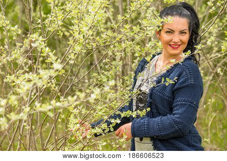 Beauty woman posing in nature with young leaf of tree