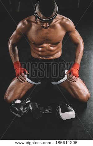 High Angle View Of Muay Thai Fighter With Mongkhon On Head Sitting On Floor