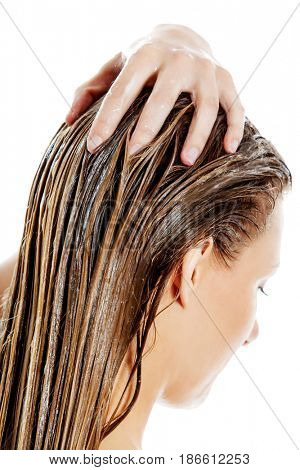 Photo of woman applying hair conditioner.