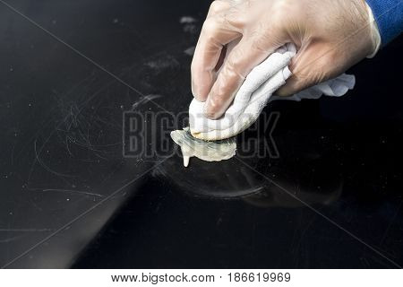 Distributing the polishing paste on the surface of the varnish