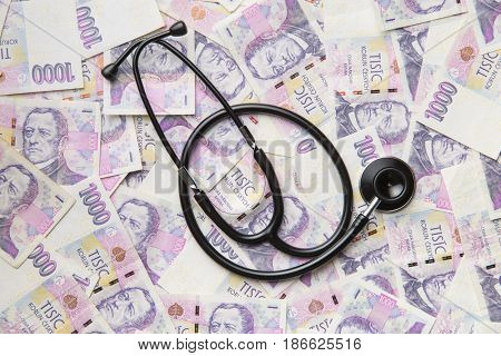 Stethoscope on money czech background. Top view.