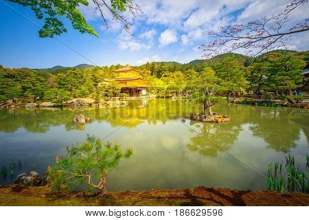 Scenic landmark Kinkakuji or Rokuonji, Unesco site of Kyoto, reflected on lake.The Golden Pavilion, whose top two floors are completely covered in gold leaf, is a ancient Zen temple. Day light shot.