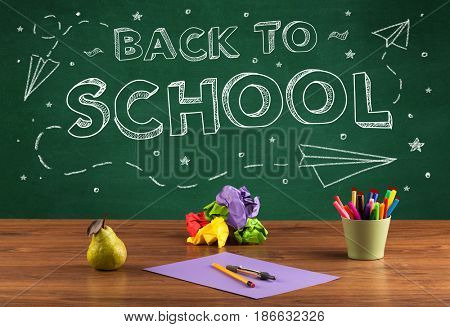 Back to school concepty with writing on blackboard and desk, apple, books, items