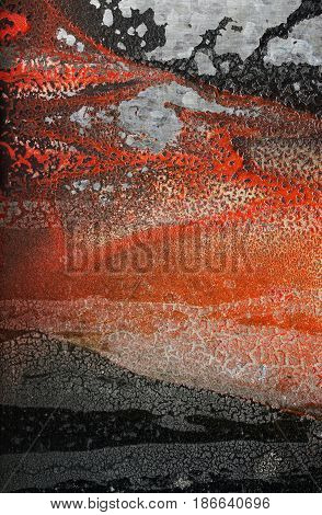 Relief forms on the wall formed by cracked dried orange and black Vibrant paint. Abstract textured grunge background-Close up. Roughcracked surface with associative elements. Association concept