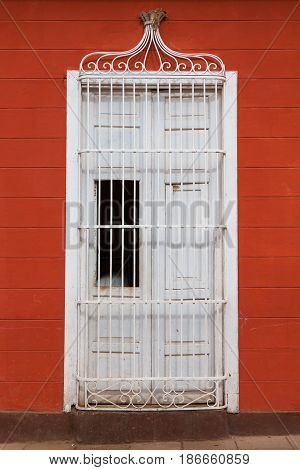 Typical colonial building with door iron grate in Trinidad Cuba
