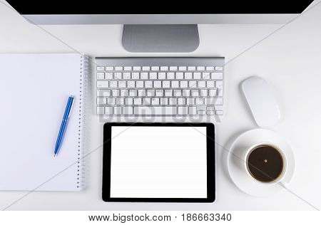 Office table with computer wireless computer keyboard and mouse cup of coffee tablet computer.copy space notebook. empty screen