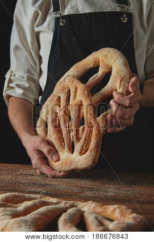Baker is holding fougas bread