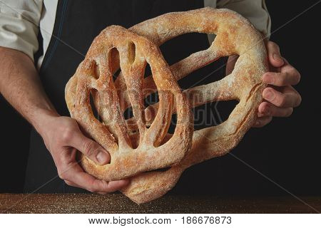 Baker is holding fougas bread