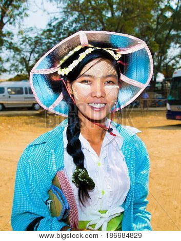 INNWA,MYANMAR - MARC 6, 2017: Unidentified young Myanmar woman with thanaka on her smile face is happiness in Innwa on March 6, 2017. Thanaka is a yellowish-white cosmetic paste made from ground bark