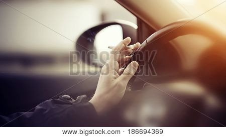 Smoking cigarettes at the wheel while driving a car.