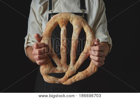 Baker's hands hold fougas bread