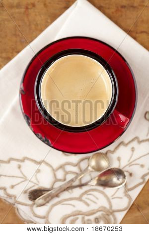 espressokaffe i röd emalj mugg, två gamla silver skedar, broderad nupkin, grunda dof
