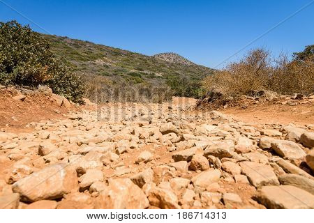 The dirt road strewn with large stones. The peninsula Kalydon. Crete. Greece.