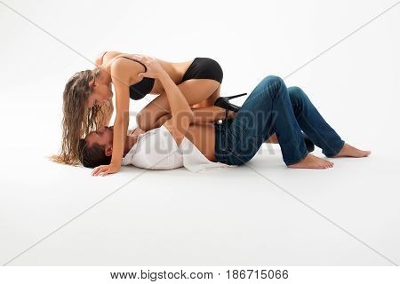 girl or adorable woman with long hair in sexy black bra shorts shoes with high heels and handsome man or macho lying on floor isolated on white. Young couple in love. Passion and foreplay