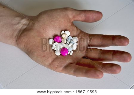 Heap of colorful medicines in his palm