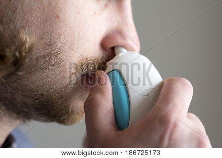 bearded young man and nose inhaler application