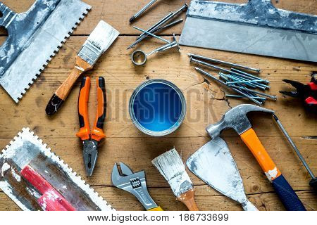builder work with professional repairing implements set for decorating and painting on wooden background top view