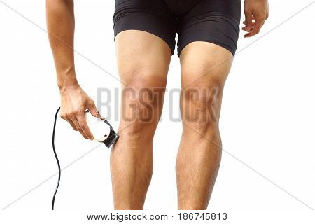A professional cyclist shaving his legs using hair clipper for improving aerodynamics isolated